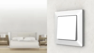 Schalter Deltaline von Siemens an der Wand und im Hintergrund ein Sofa.