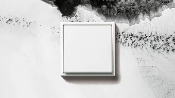 Schalter in der Farbe Mattweiß des Herstellers Jung an der Wand montiert.