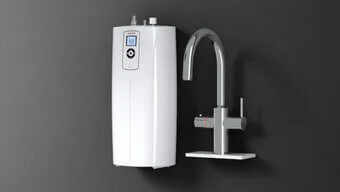 Das Bild zeigt einen Heißwasserautomat HOT 2.6 N Premium neben einem Wasserhahn