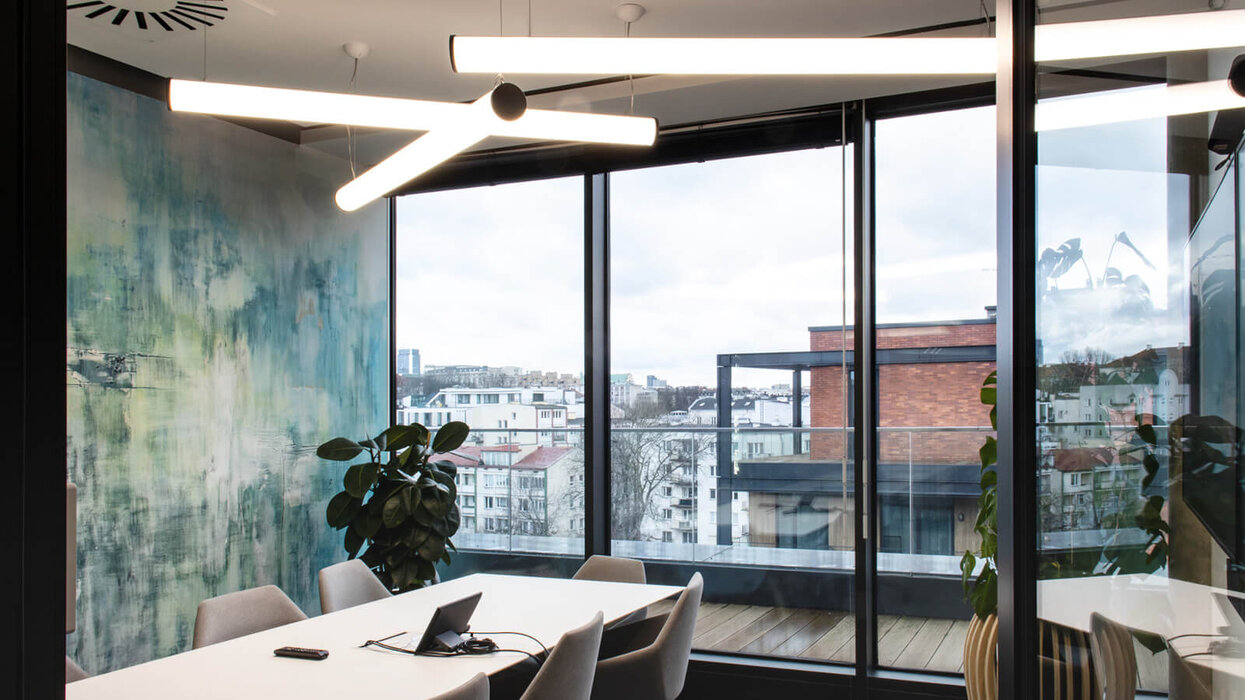 Modernes Büro mit Schreibtisch und dem Blick aus dem Fenster im Hintergrund.